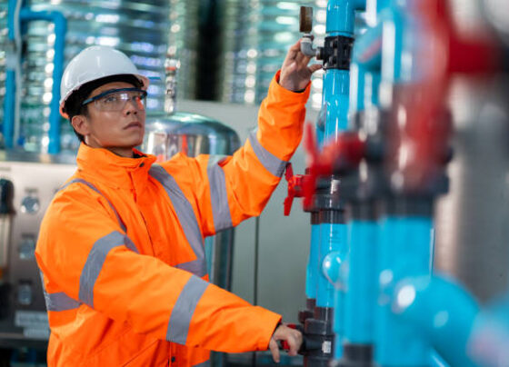 Asian technician engineer maintenance Drinking water pipe and pressure tank . Filter system for purified water.