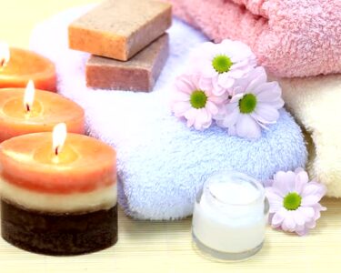 Towels, candles, soap and cream on bamboo rug. Spa Treatment.
