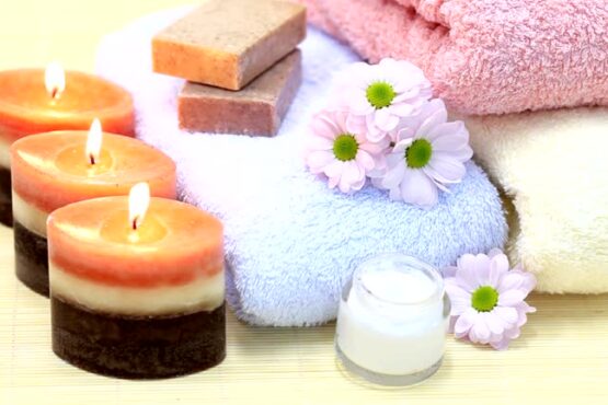 Towels, candles, soap and cream on bamboo rug. Spa Treatment.
