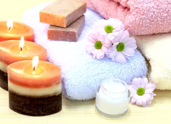 Towels, candles, soap and cream on bamboo rug. Spa Treatment.